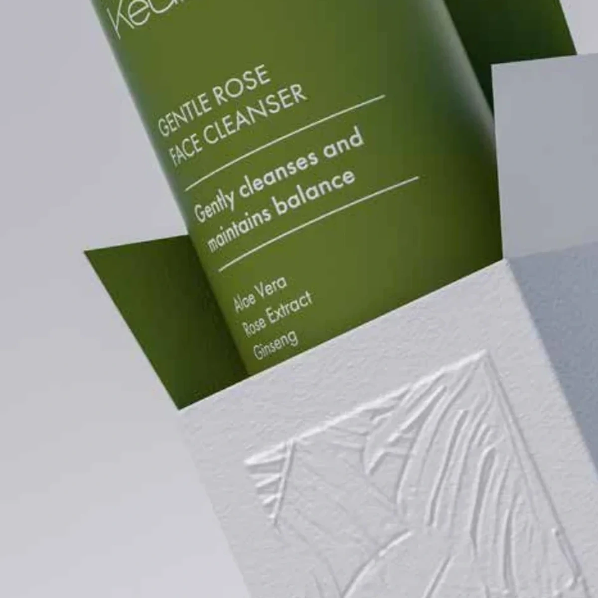 Packaging cosmético KEULLIN con envase verde y estuche blanco en relieve