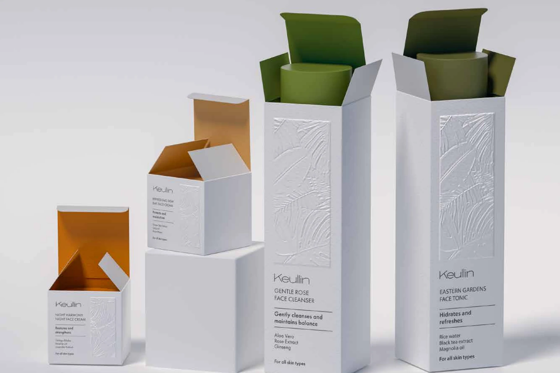 KEULLIN cosmetic packaging range with embossed white cartons and green and amber interiors